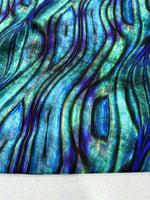 Close-up of iridescent wave pattern fabric in blue and green hues with textured design