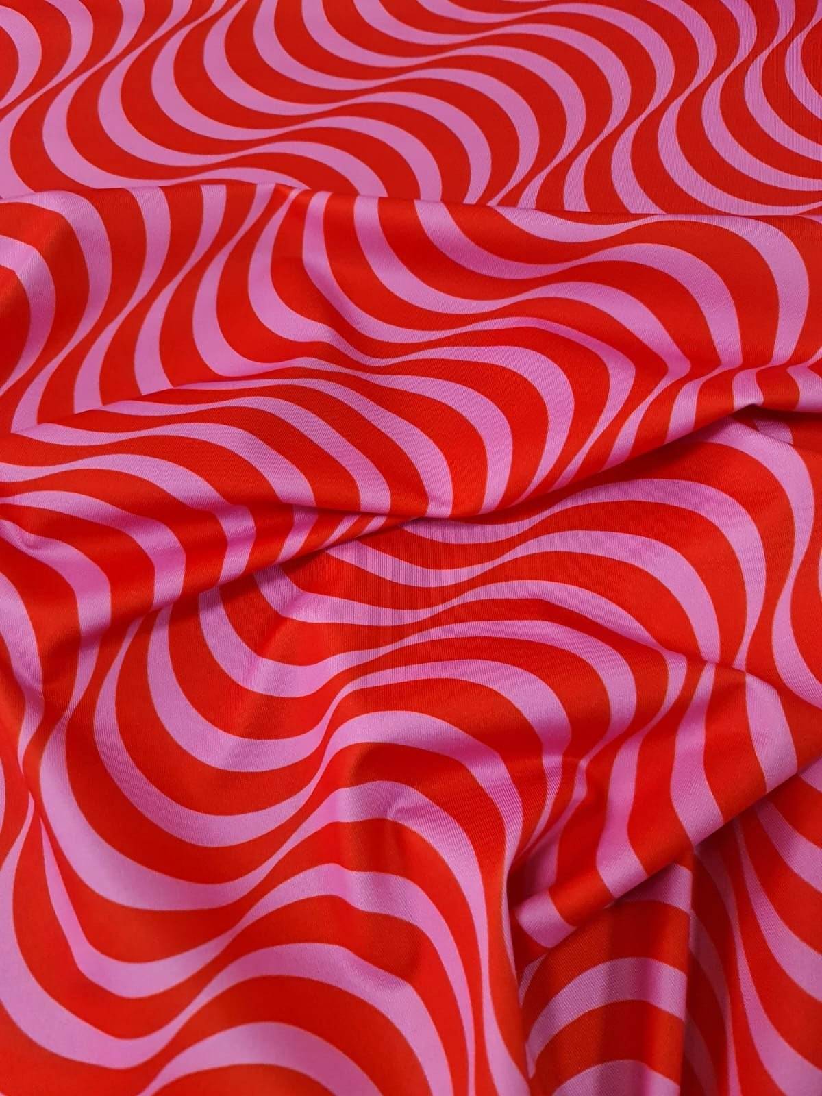 Red and pink striped wave pattern fabric with vibrant decorative design, ideal for sewing and crafting projects