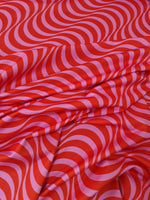 Red pink striped wave pattern fabric with vibrant decorative textile design for sewing projects
