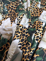 Floral and cheetah pattern fabric with white roses and green leaves on animal print background