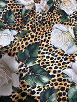 Floral and cheetah pattern fabric with white roses and green leaves on a cheetah print background
