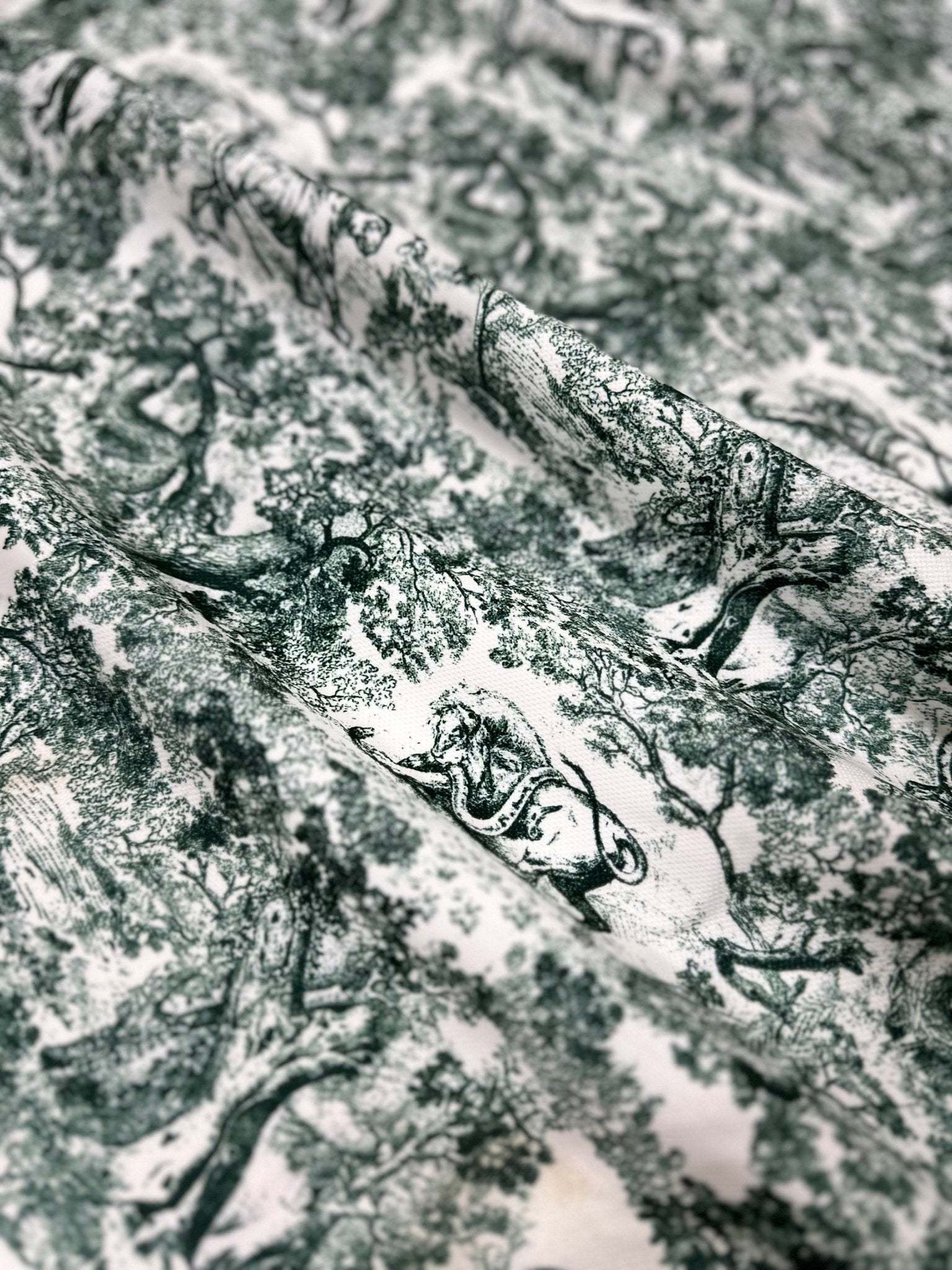 Green and white wild forest animal print fabric with detailed nature-inspired design for sewing and home decor projects