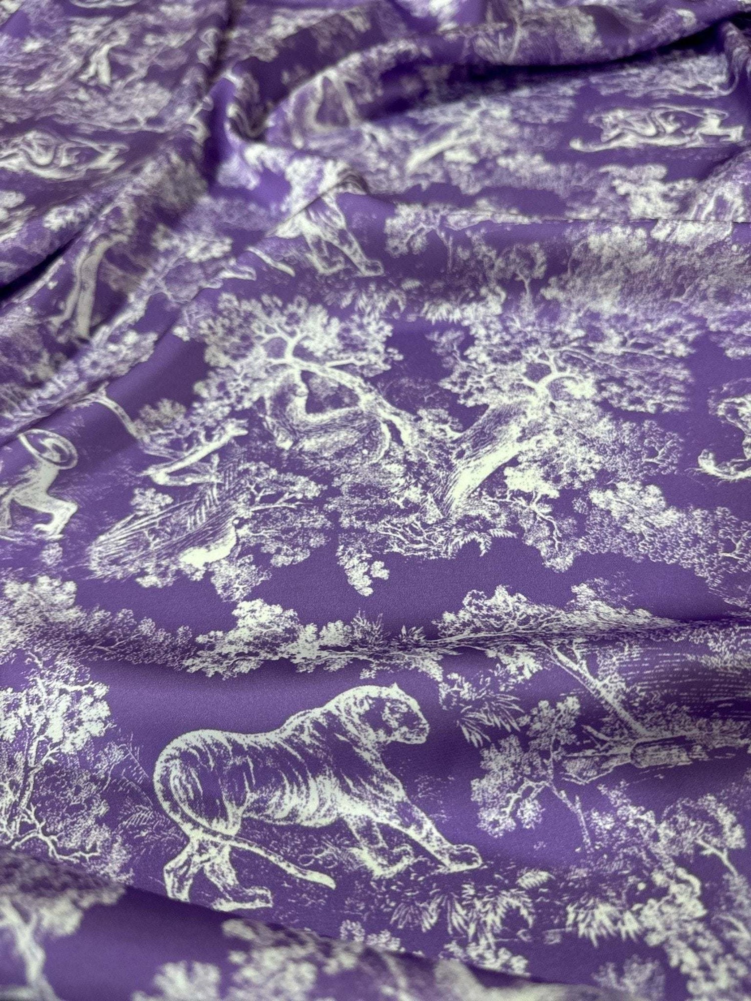 Purple fabric with white wild forest animal pattern for upholstery and crafts