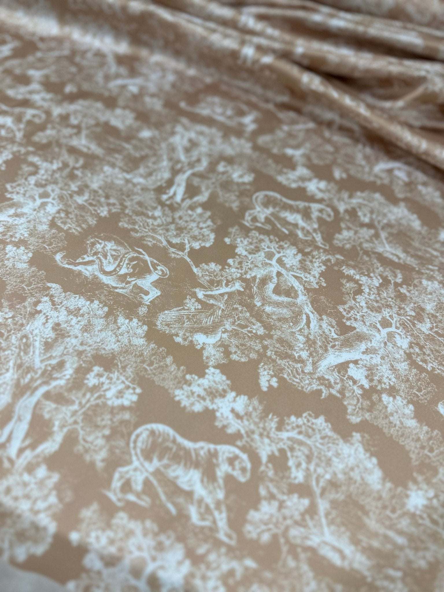 Beige fabric with white wild forest animal pattern for sewing projects