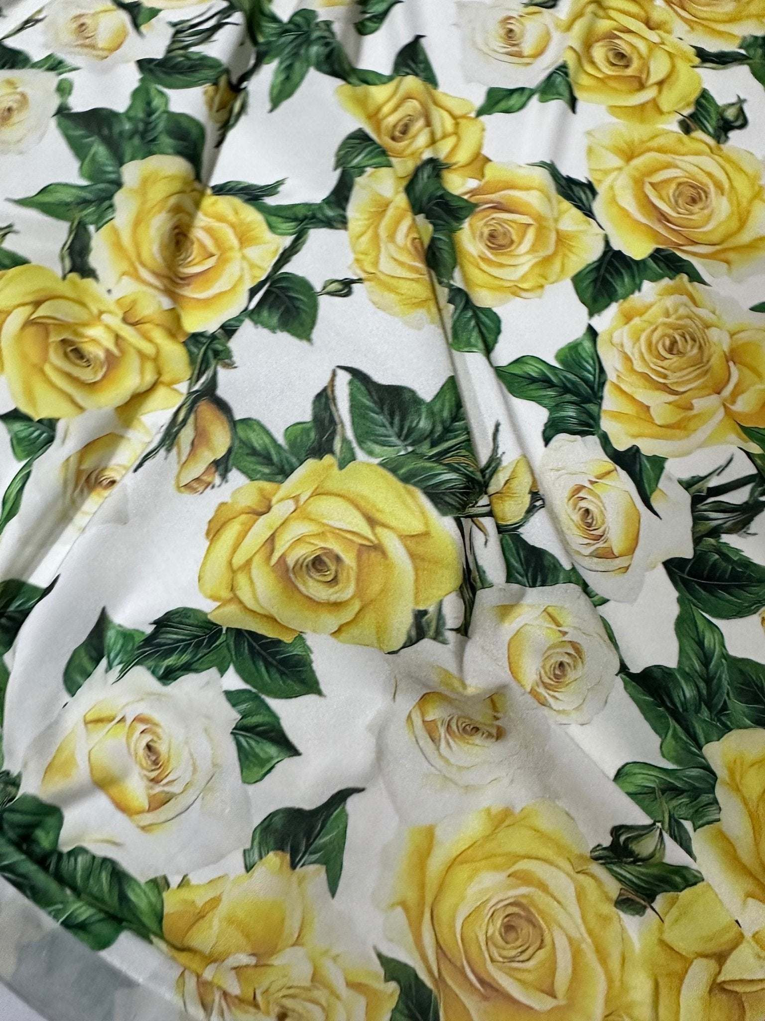 Yellow floral rose pattern fabric with green leaves on white background, sold by the yard for crafts and home decor projects