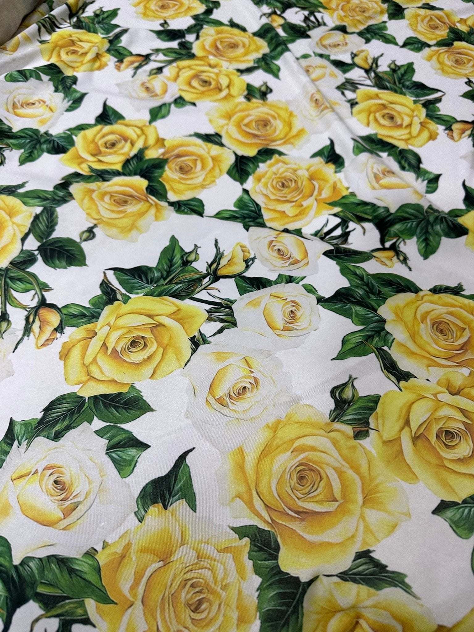 Yellow floral rose pattern fabric with green leaves on white background for crafts and home decor
