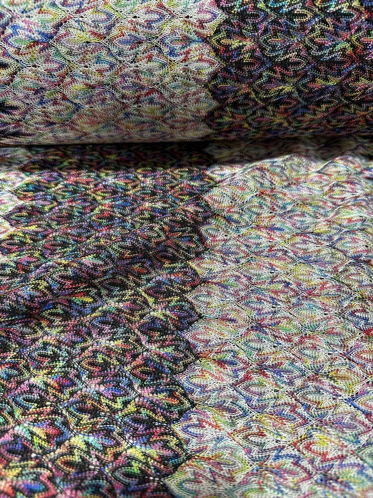 Black and white zigzag knit jersey fabric with colorful multicolor chevron pattern and soft texture