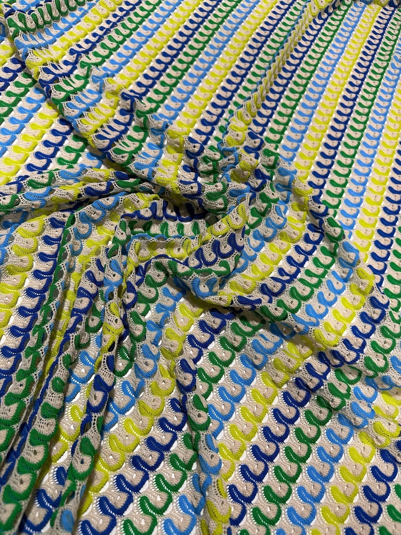 Luxury zigzag knit jersey fabric with blue, yellow, and green chevron pattern close-up
