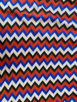 Luxury zigzag knit jersey fabric with blue, red, black, and sugar pink hues in a vibrant chevron pattern