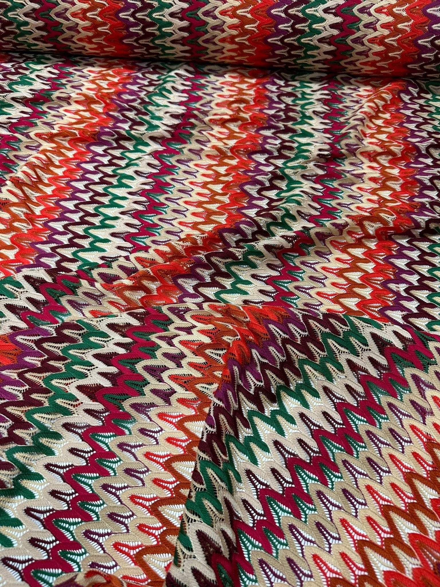 Multicolor zigzag knit jersey fabric with vibrant chevron pattern and soft texture.
