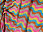 Luxury zigzag knit jersey fabric with pink, blue, yellow, and orange chevron pattern