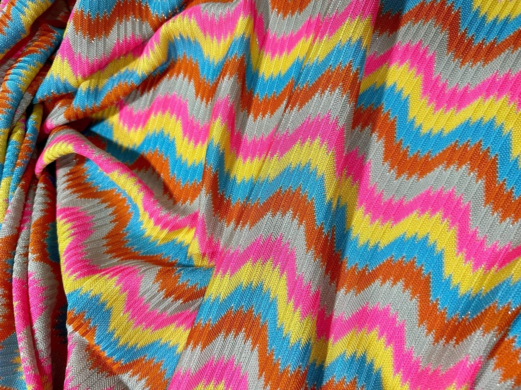 Luxury zigzag knit jersey fabric with pink, blue, yellow, and orange chevron pattern