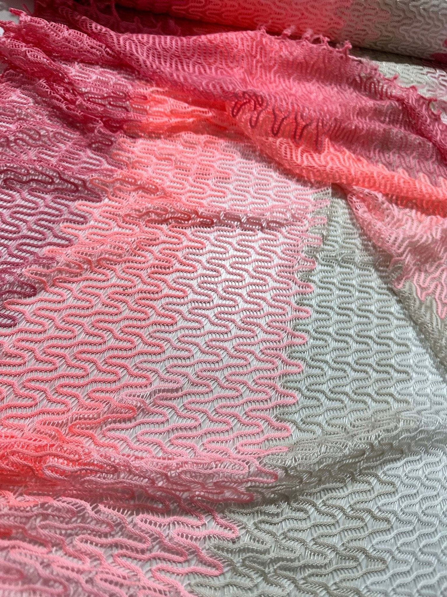 Chevron zigzag knit jersey fabric in pink and white pattern with soft texture, ideal for garments and sewing projects