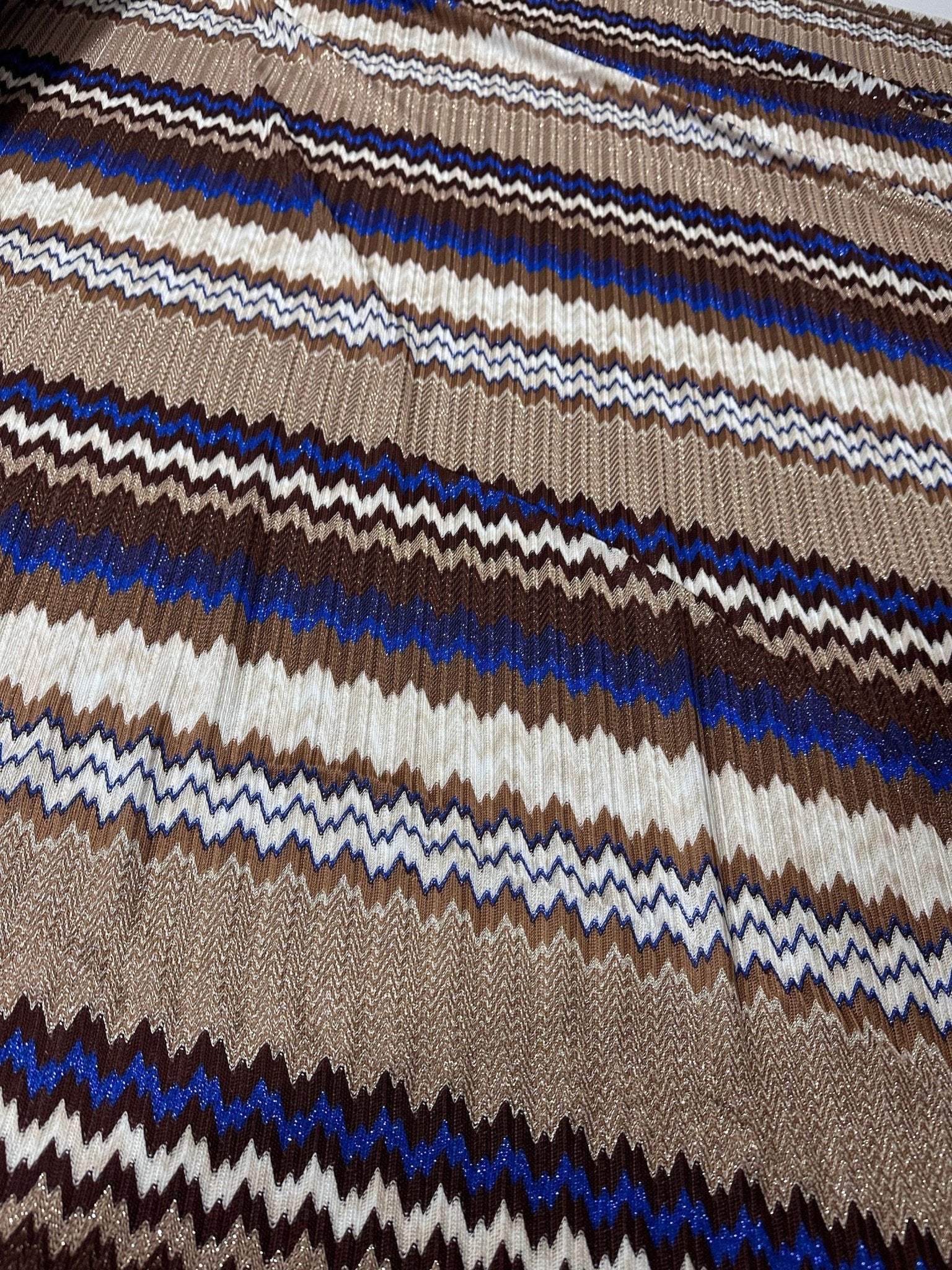 close-up of shimmer brown zigzag knit mesh fabric with blue, brown, and white zigzag patterns and elastic jersey texture