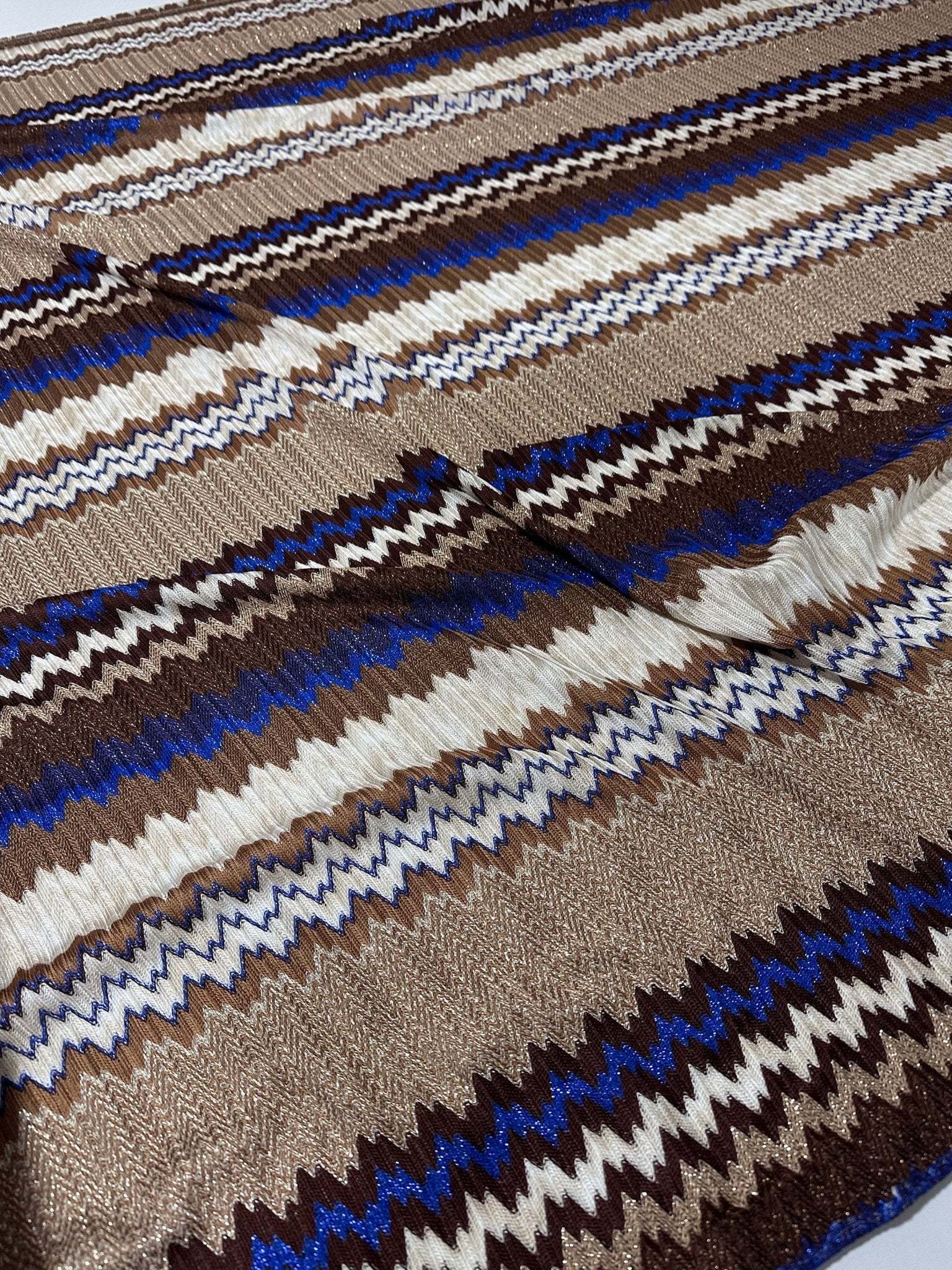 Shimmering zigzag knit mesh fabric with blue, brown, and white elastic jersey stripes for fashion apparel